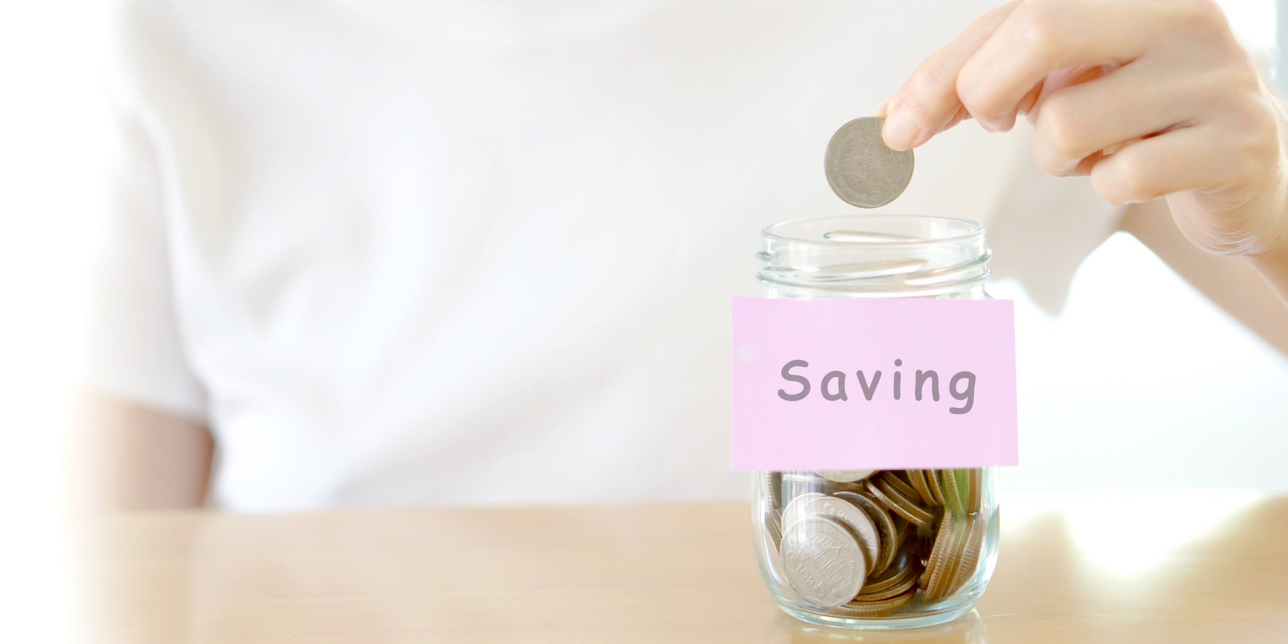 Woman hands with coins in glass jar, close up tax savings image